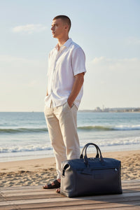 Button Down SF navy tumbled leather holdall bag with shark fin detailing and shoulder strap.
