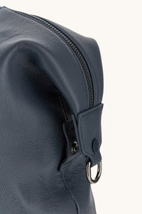 Button Down SF navy tumbled leather holdall bag with shark fin detailing, handles, and shoulder strap.