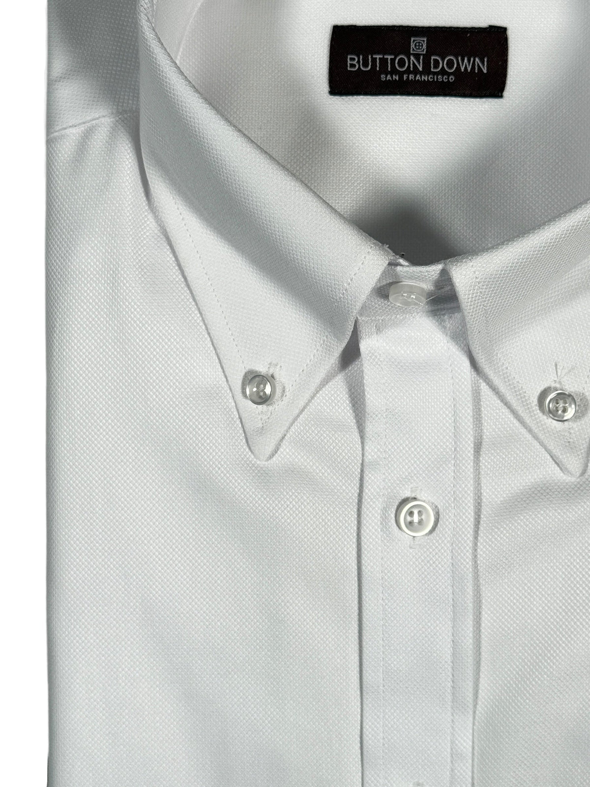 White button-up shirt with collar and buttons, featuring 'Button Down San Francisco' label.