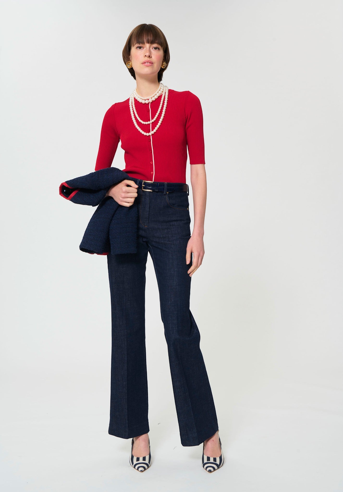 Button Down SF cerise red ribbed knit short-sleeve cardigan with white trim and pearl necklace.