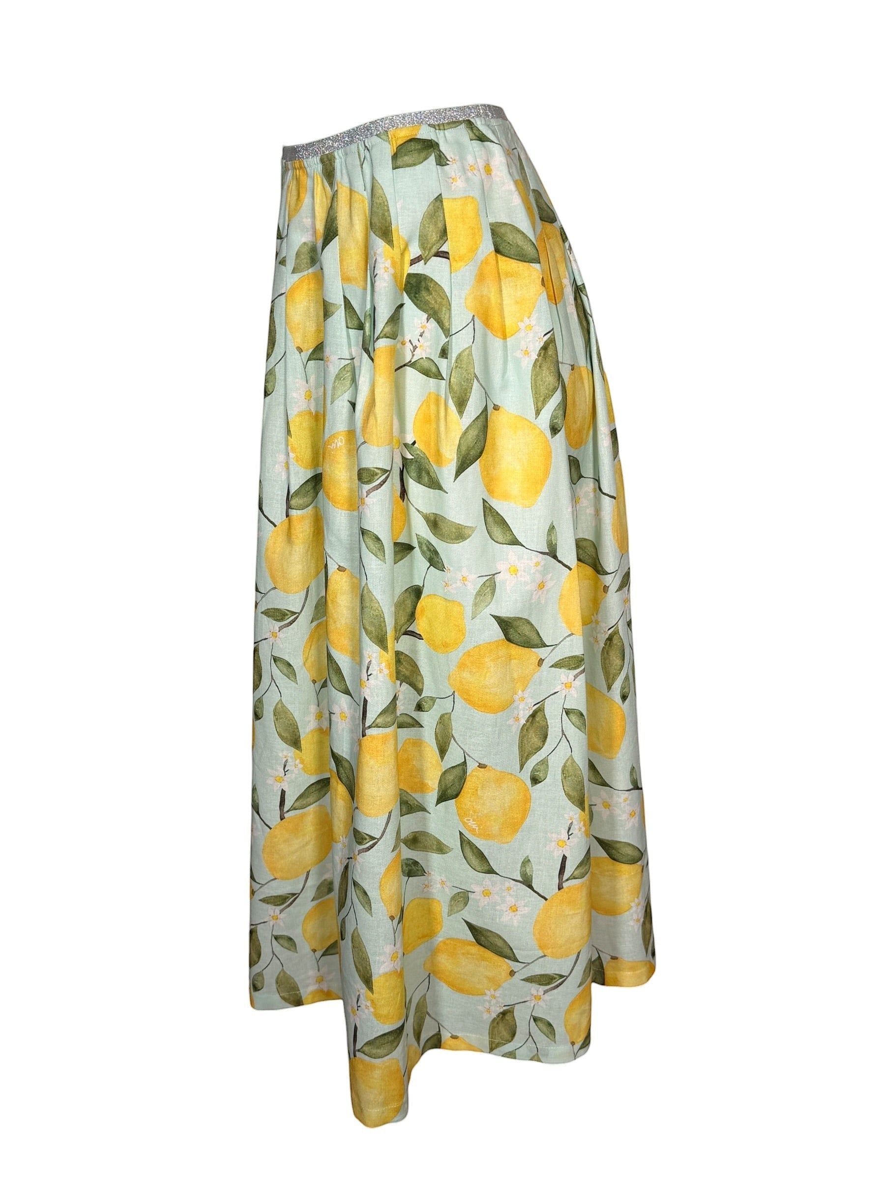 Button Down SF OUI Lemons Skirt: A-line midi skirt in light green with a yellow lemon print, featuring an elasticated waistband with metallic thread detail. Made from linen and cotton.