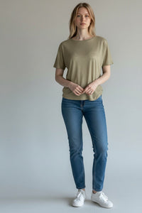 Button Down SF seagrass green short sleeve linen tee with a subtle shimmer, worn by a woman with blonde hair and blue jeans.